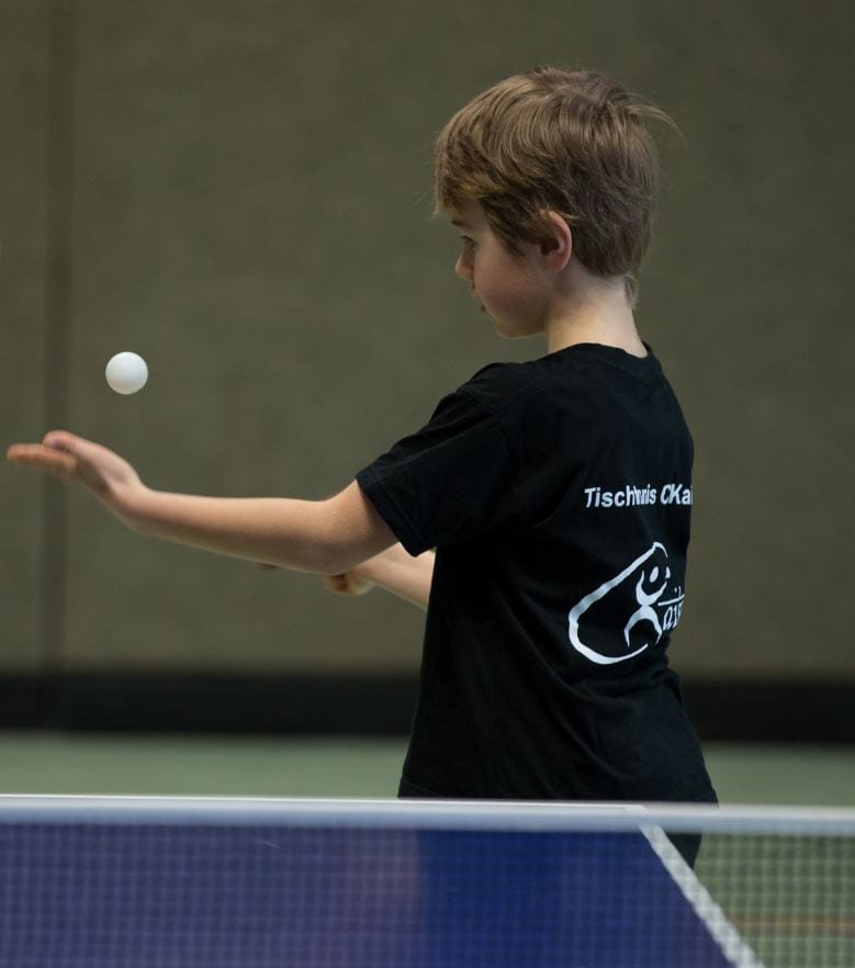 Jugendlicher beim Tischtennisspiel, konzentriert beim Schmettern, im Sportverein CK-Tischtennis, Sporttraining, Tennisplatte, Freizeitaktivität, Sportverein, Tischecken, Hobby, Bewegung, Indoor-Sport.
