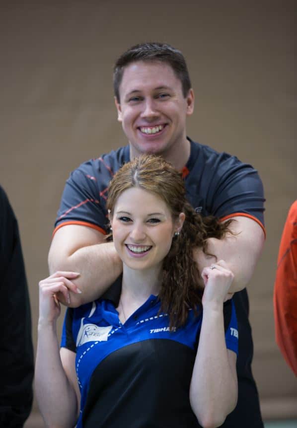 CK-Tischtennis Sportteam bei einem Mannschaftsevent, fröhlich und motiviert, in Teamkleidung, indoor, Fokus auf Tischtennis und Teamgeist, professionelle Sportfotografie.