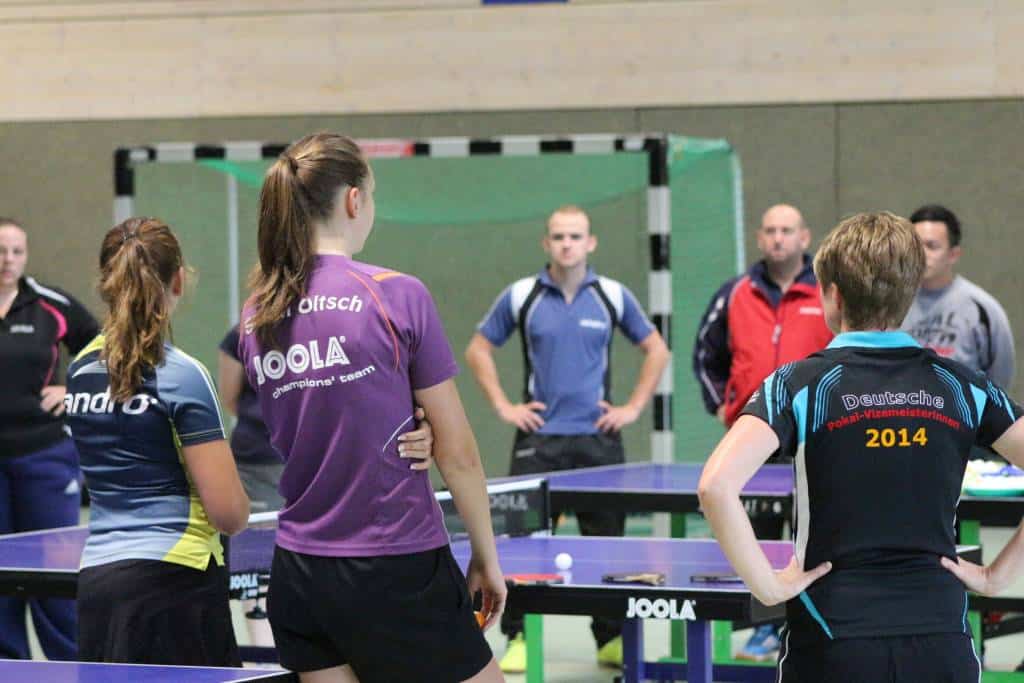 Damen- und Herrentraining beim Tischtennis im CK-Tischtennis Club, professionelle Sportler, spannende Spielszene, Nachwuchsförderung, Tischtennis Training, Sportverein, Spielstrategie, Tischtennisschläger, Indoor-Sport, schnelle Ballwechsel.