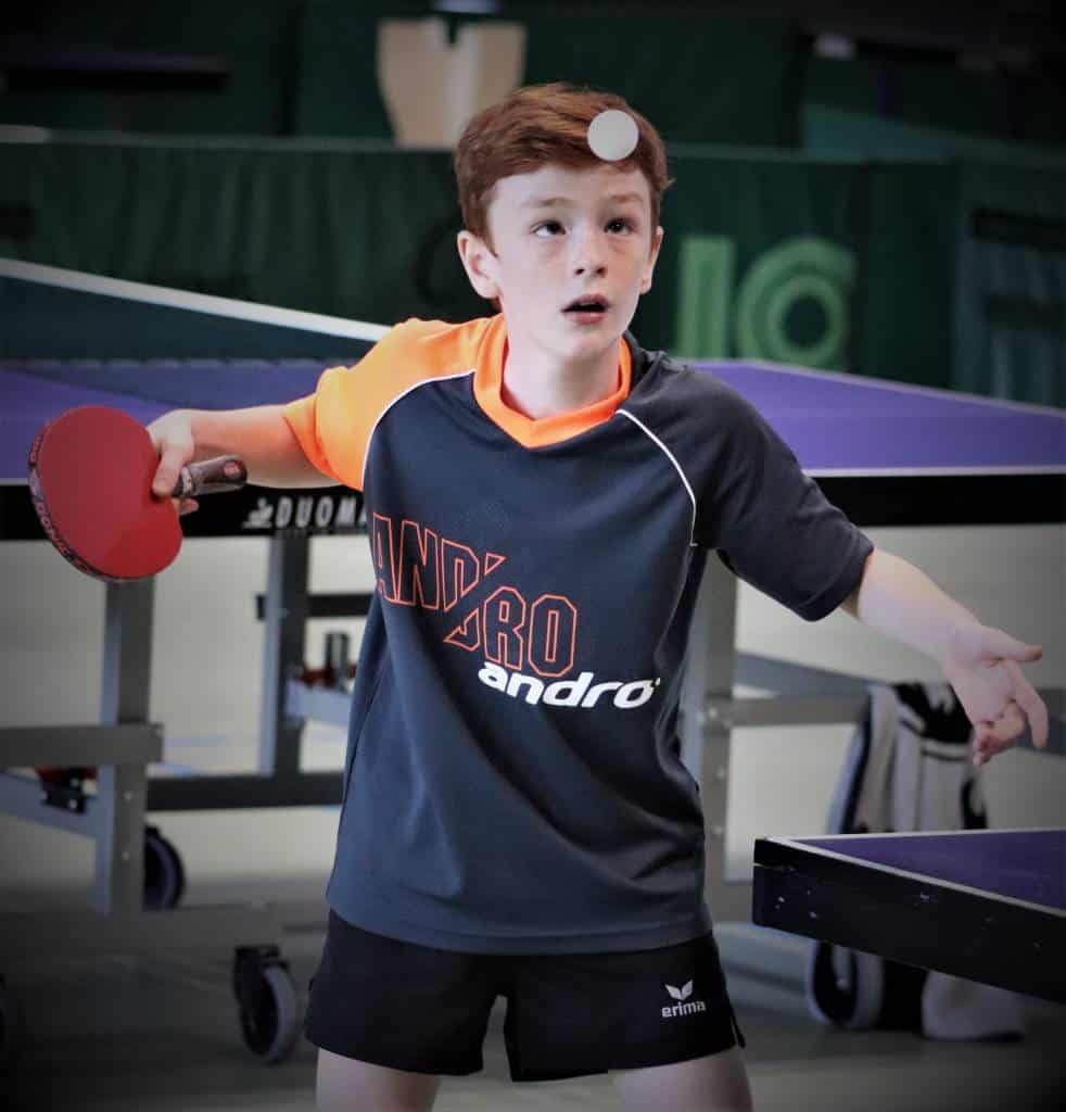 Junge Tischtennis-Spieler beim Training im CK-Tischtennis Club, mit Schläger bereit zum Schlag. Perfekte Tischtennis-Ausrüstung und Fokus auf technische Fähigkeiten.