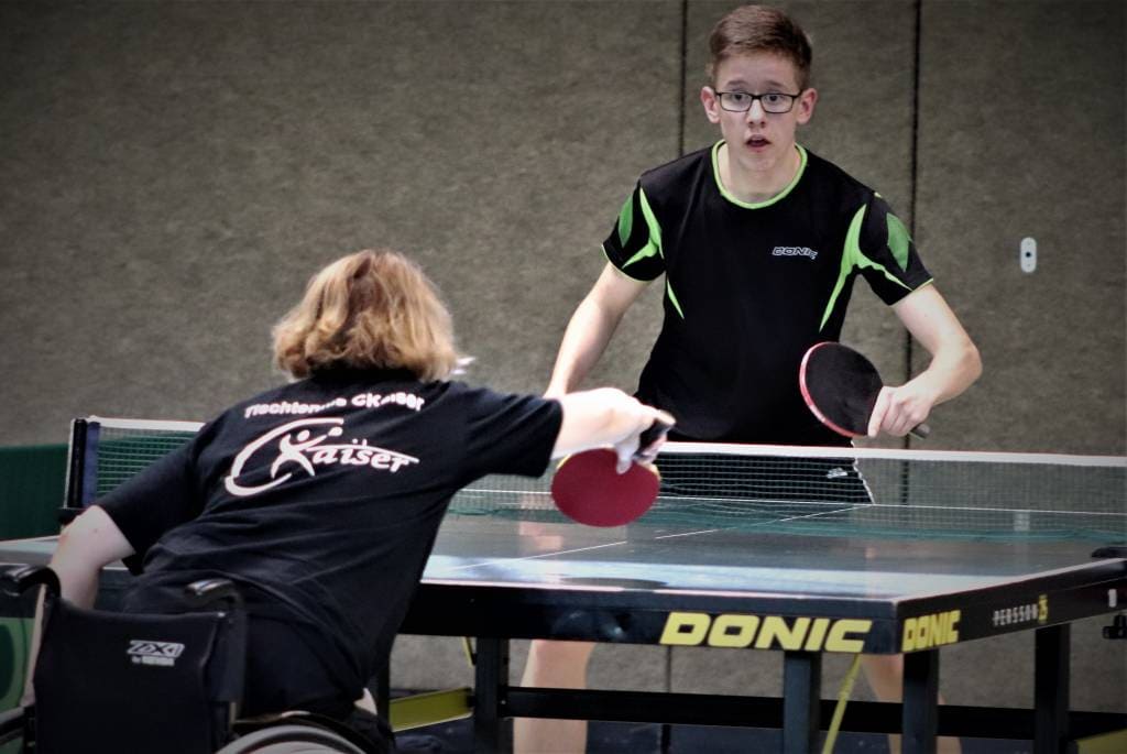 SITZTISCHTENNIS: Zwei Jugendliche beim Tischtennisspiel, inklusive Behindertensport, im Training oder Wettkampf, in einer Turnhalle, Fokus auf inklusive Sportarten, CK-Tischtennis.